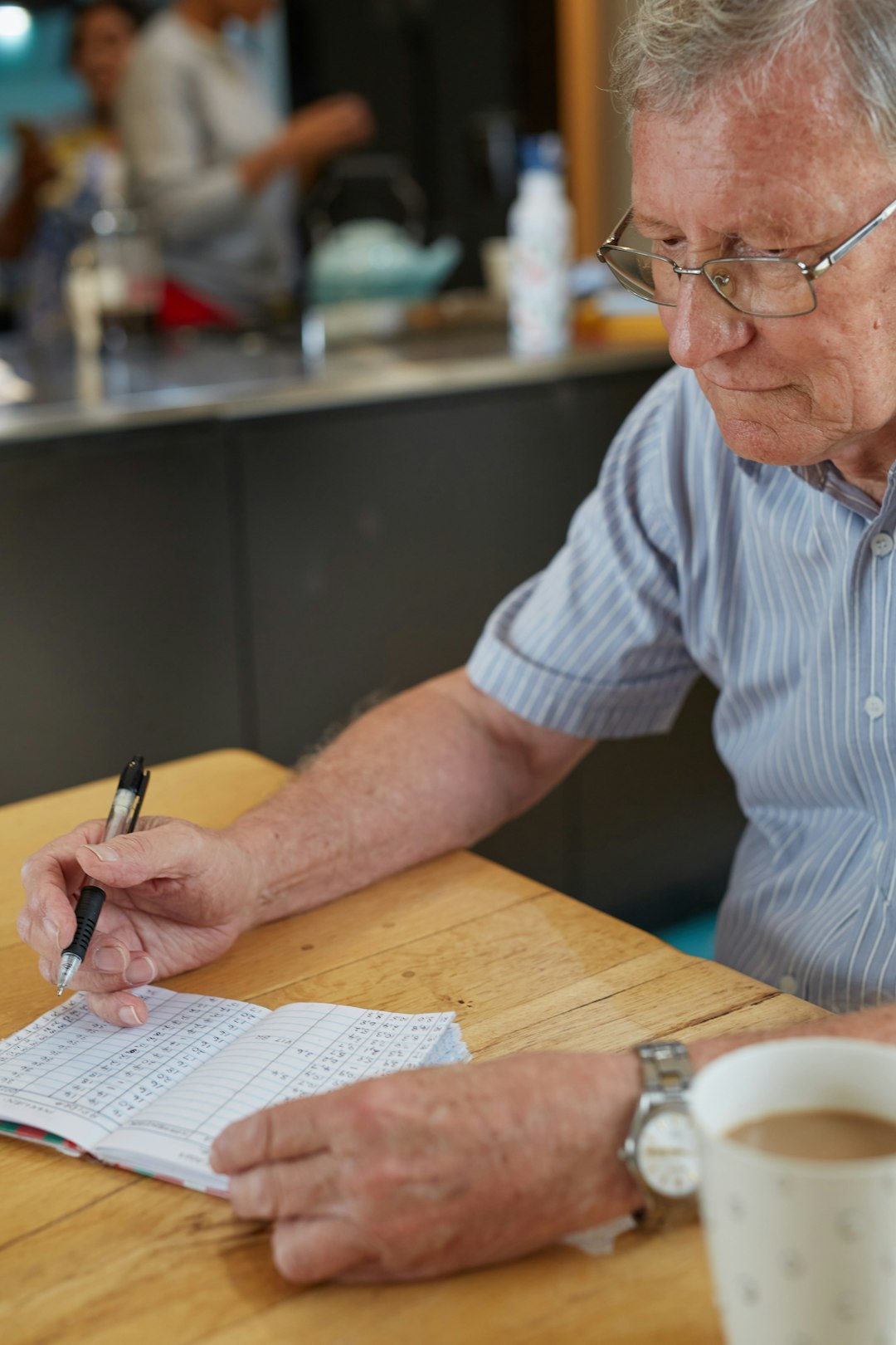 An older South African man writing down blood glucose results in his journal.